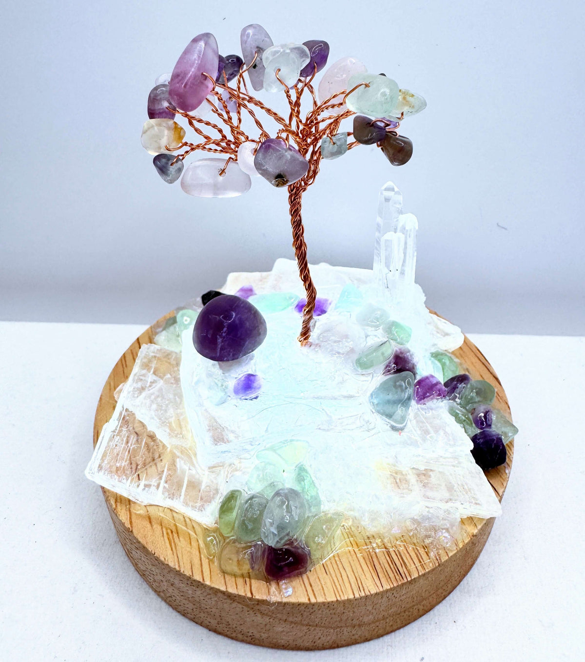 Crystal lamp featuring a handcrafted crystal tree and decorative stones in a miniature garden setting.