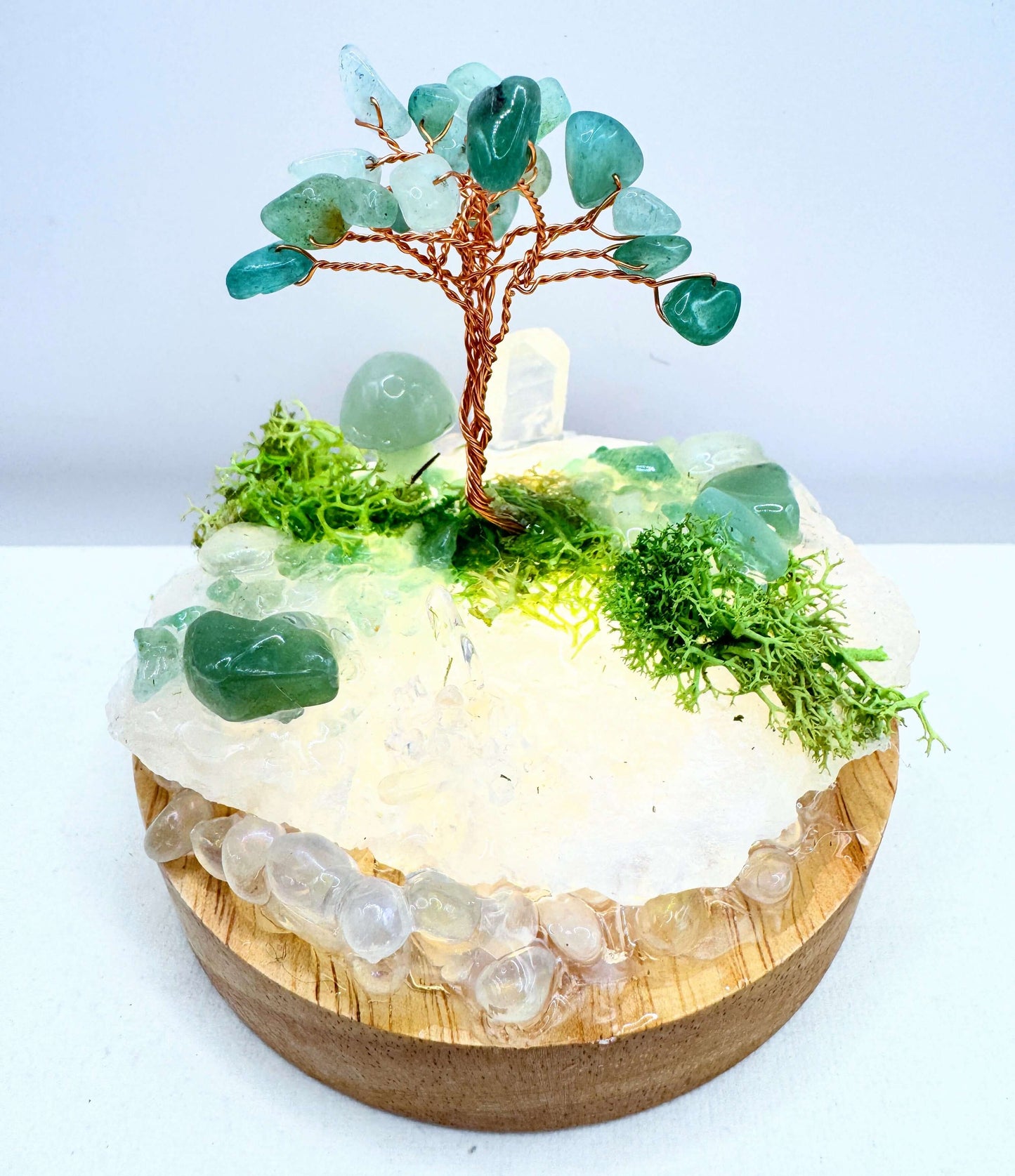 Crystal lamp featuring a handcrafted tree made of crystals and moss in an illuminated garden design.