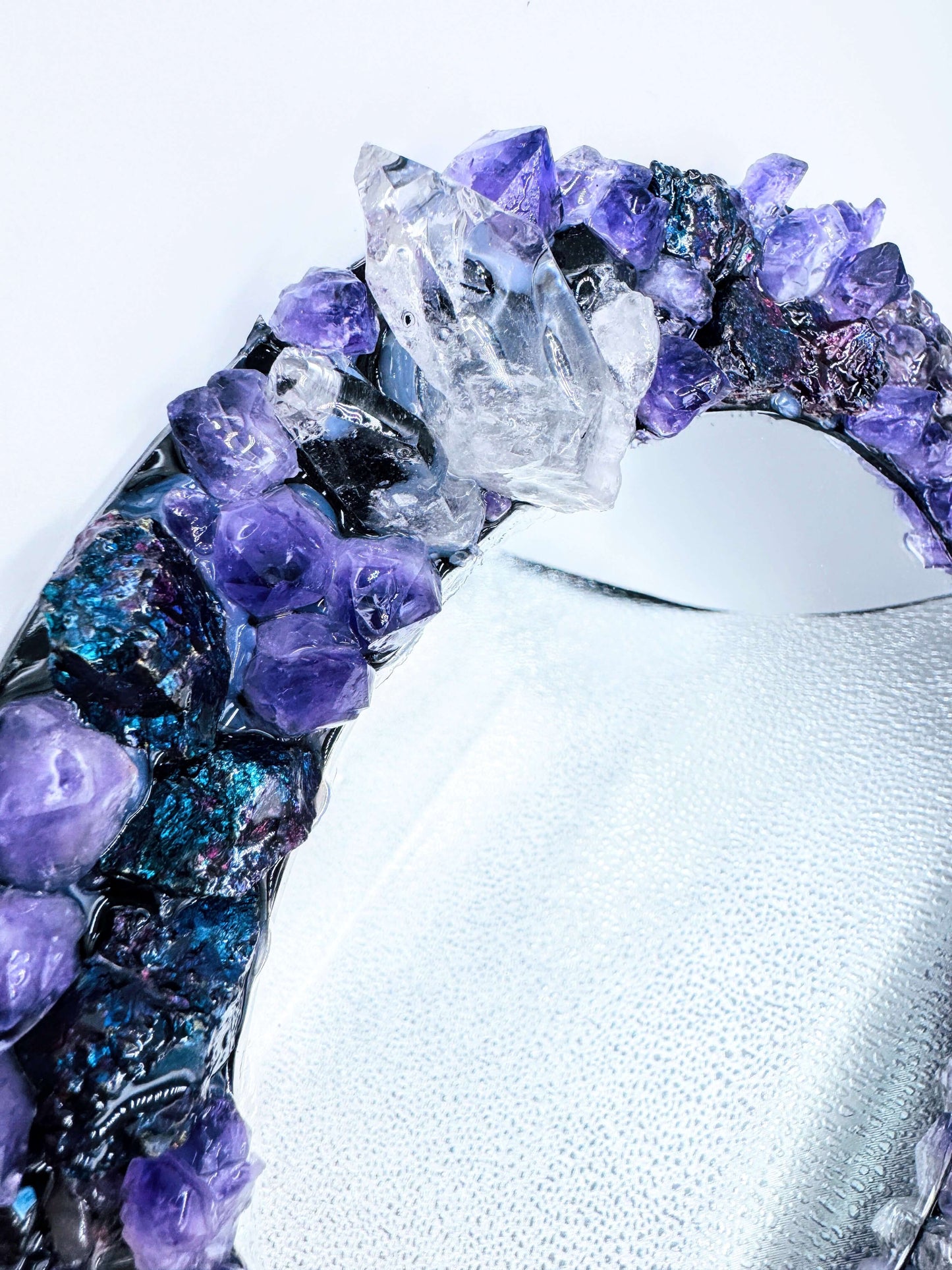 Handmade crystal mirror with gemstone border reflecting natural light