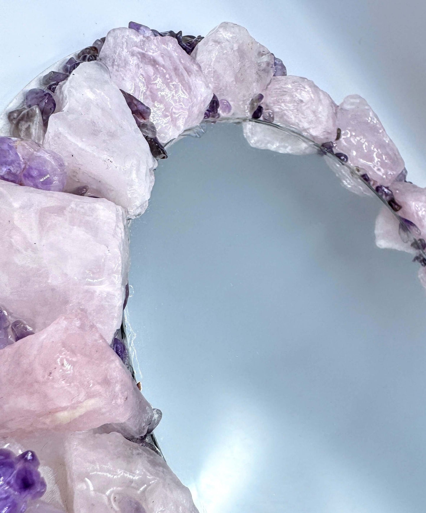 Handmade crystal mirror with gemstone border reflecting natural light