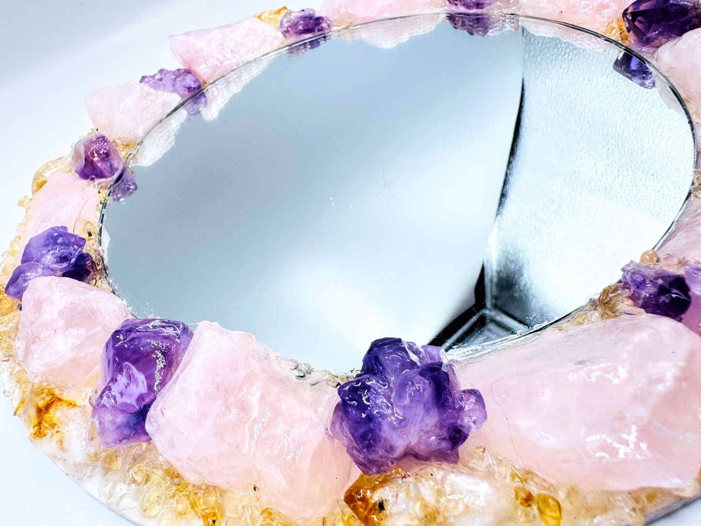 Handmade crystal mirror with gemstone border reflecting natural light