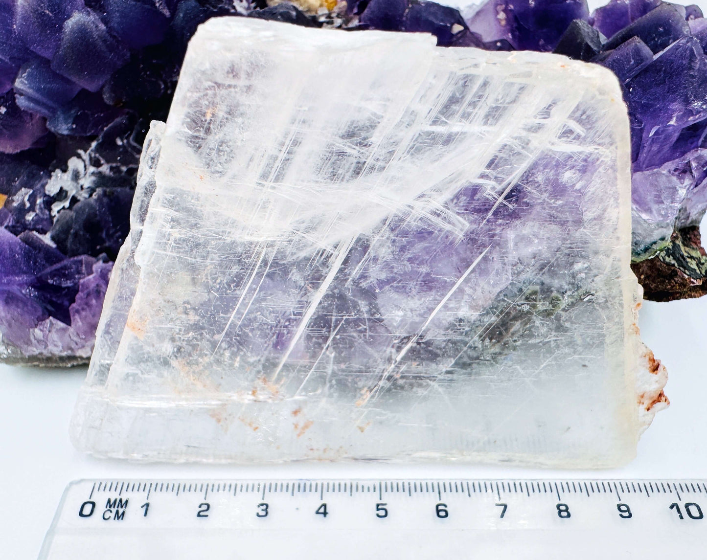 r selenite slab leaning against amethyst cluster to show the crystal’s transparency and natural clarity