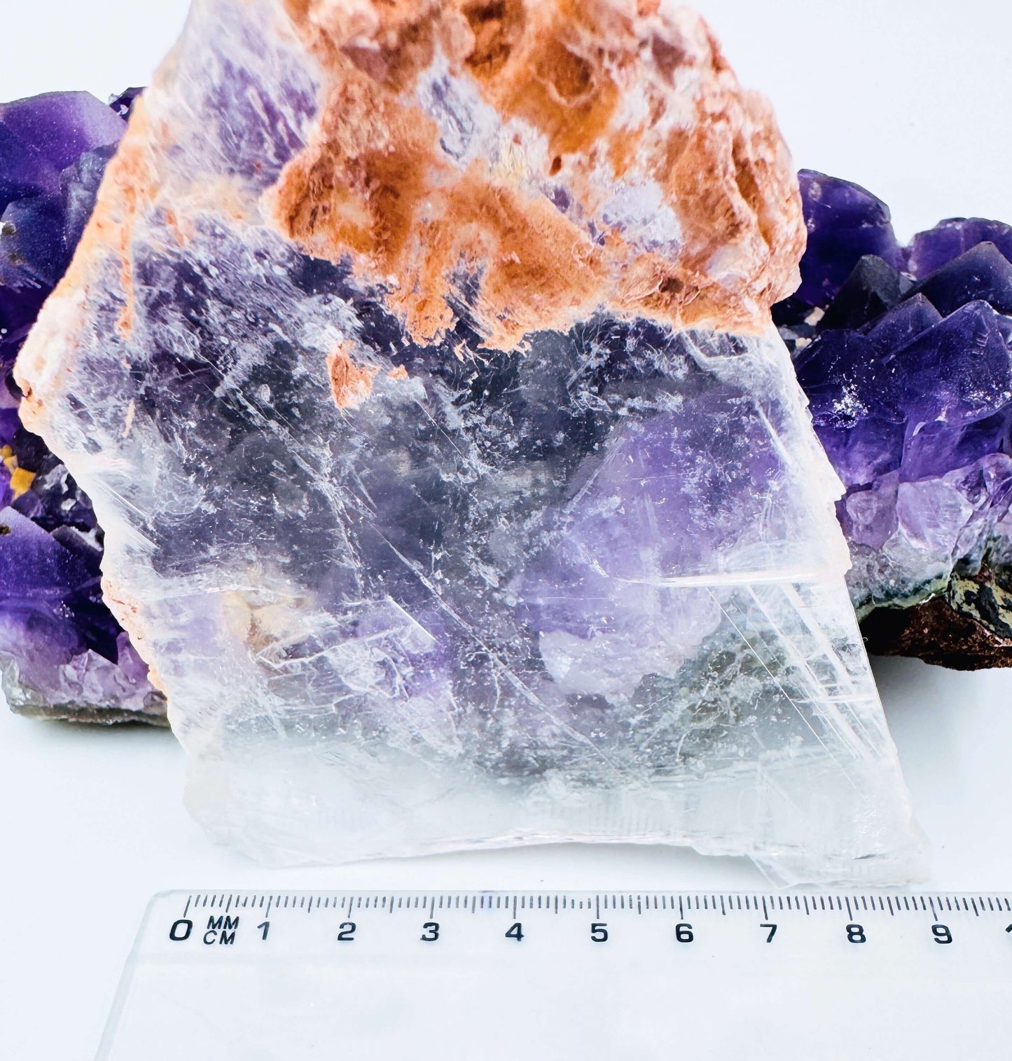 r selenite slab leaning against amethyst cluster to show the crystal’s transparency and natural clarity