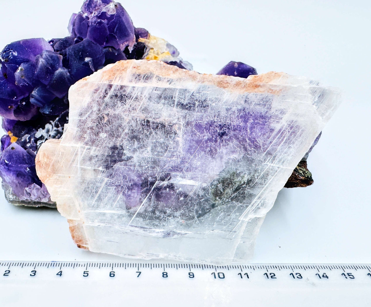 r selenite slab leaning against amethyst cluster to show the crystal’s transparency and natural clarity