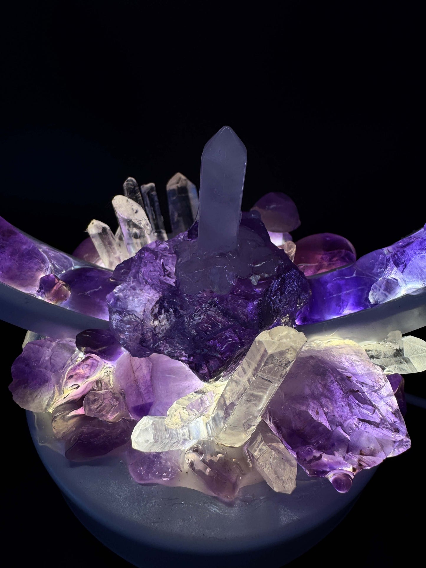 Close-up of an amethyst and clear quartz crystal lamp highlighting its luminous design and vibrant colors.