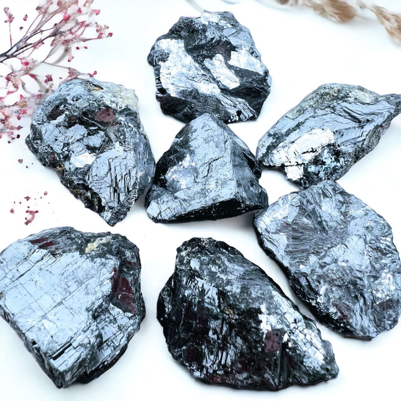 Several pieces of rough Galena crystals on white surface.