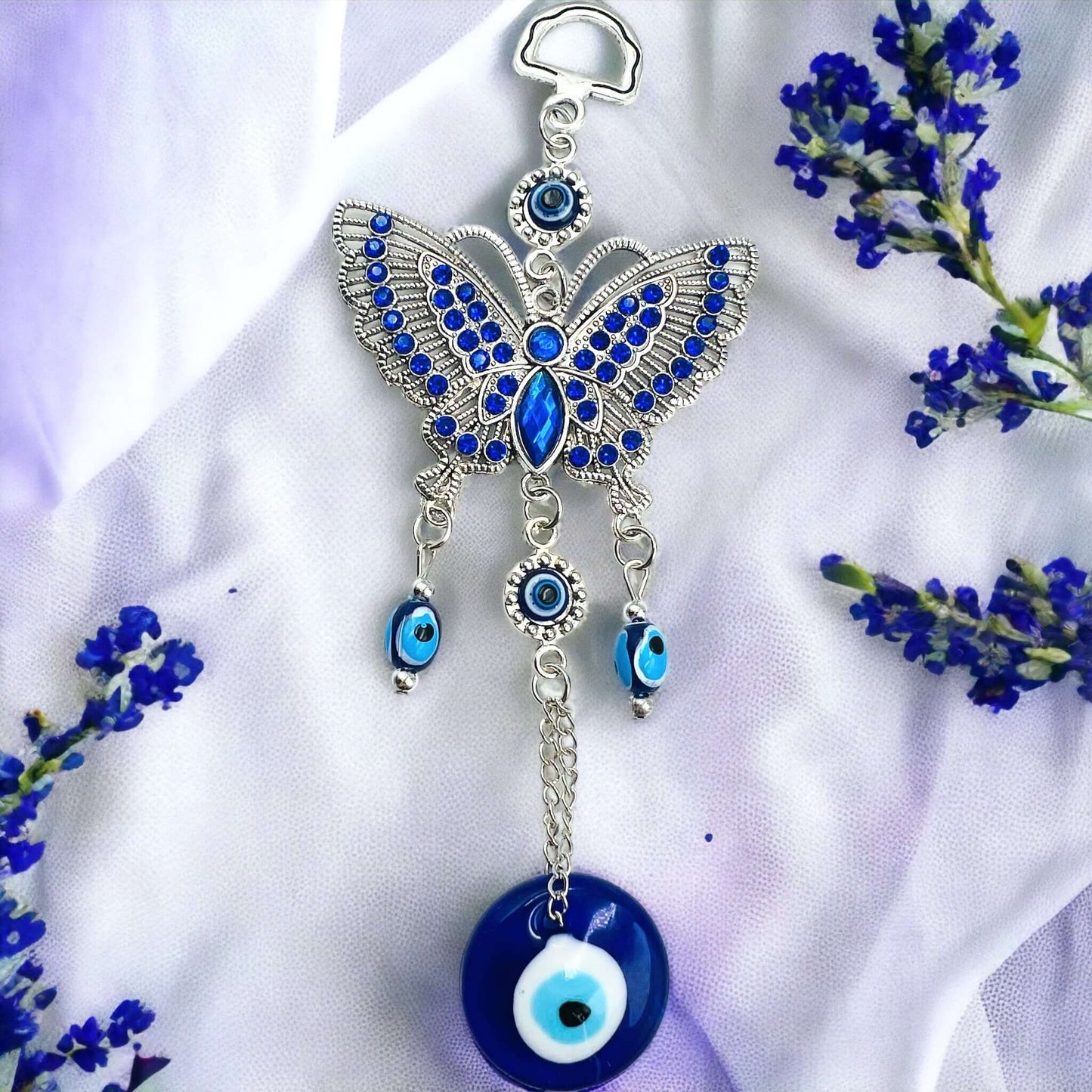 Butterfly evil eye hanger on white surface.