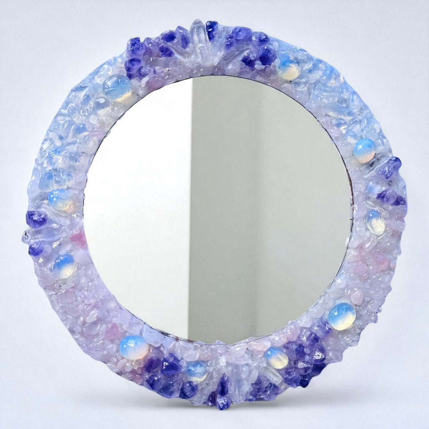 Handmade crystal mirror with gemstone border reflecting natural light