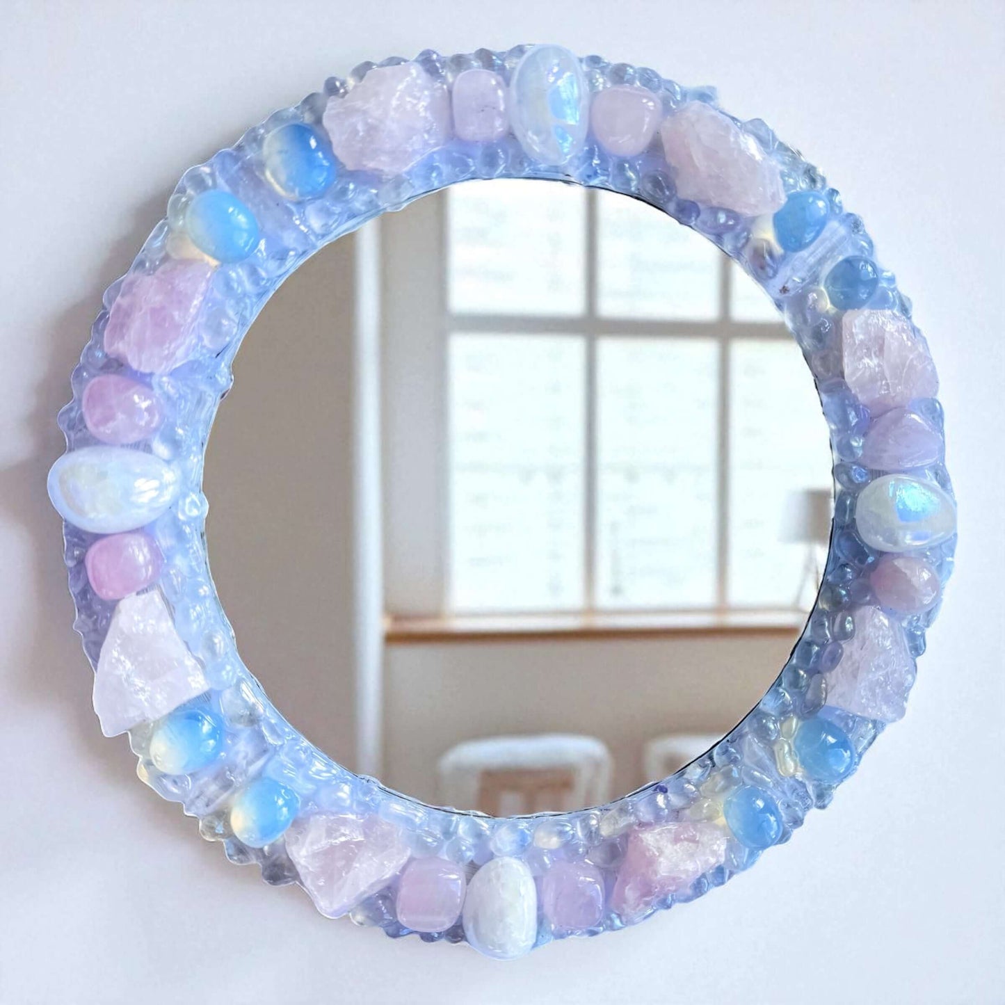 Handmade crystal mirror with gemstone border reflecting natural light