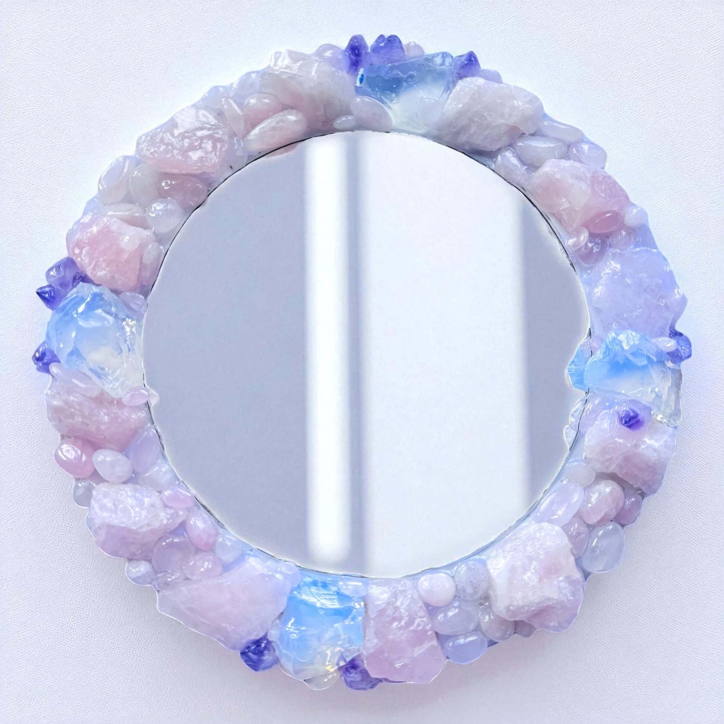 Handmade crystal mirror with gemstone border reflecting natural light