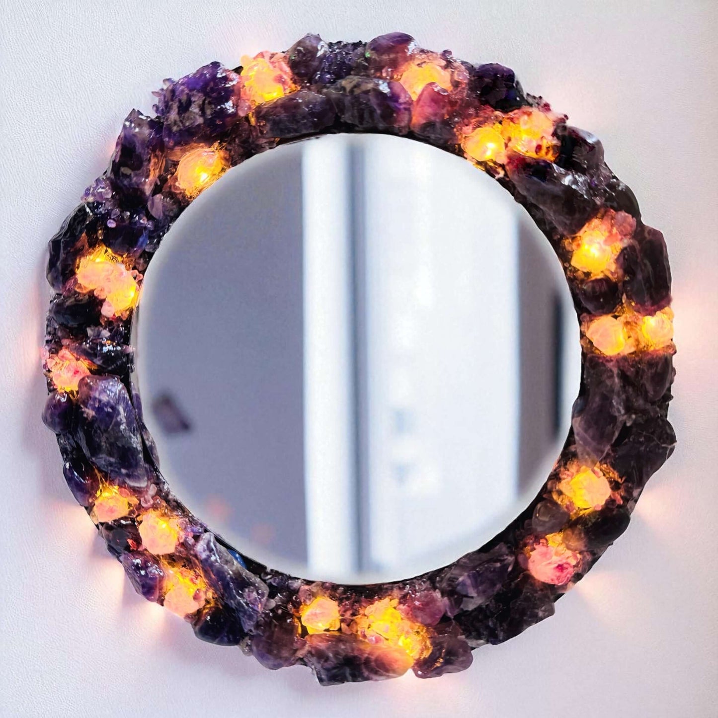 Handmade crystal mirror with gemstone border reflecting natural light