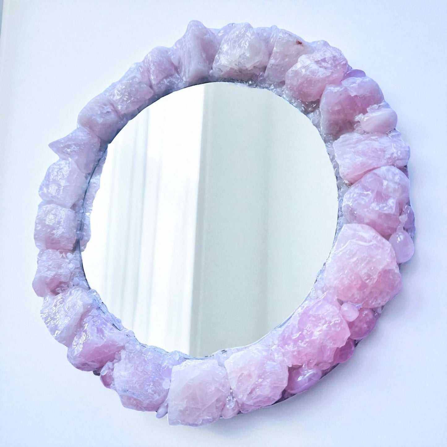 Handmade crystal mirror with gemstone border reflecting natural light