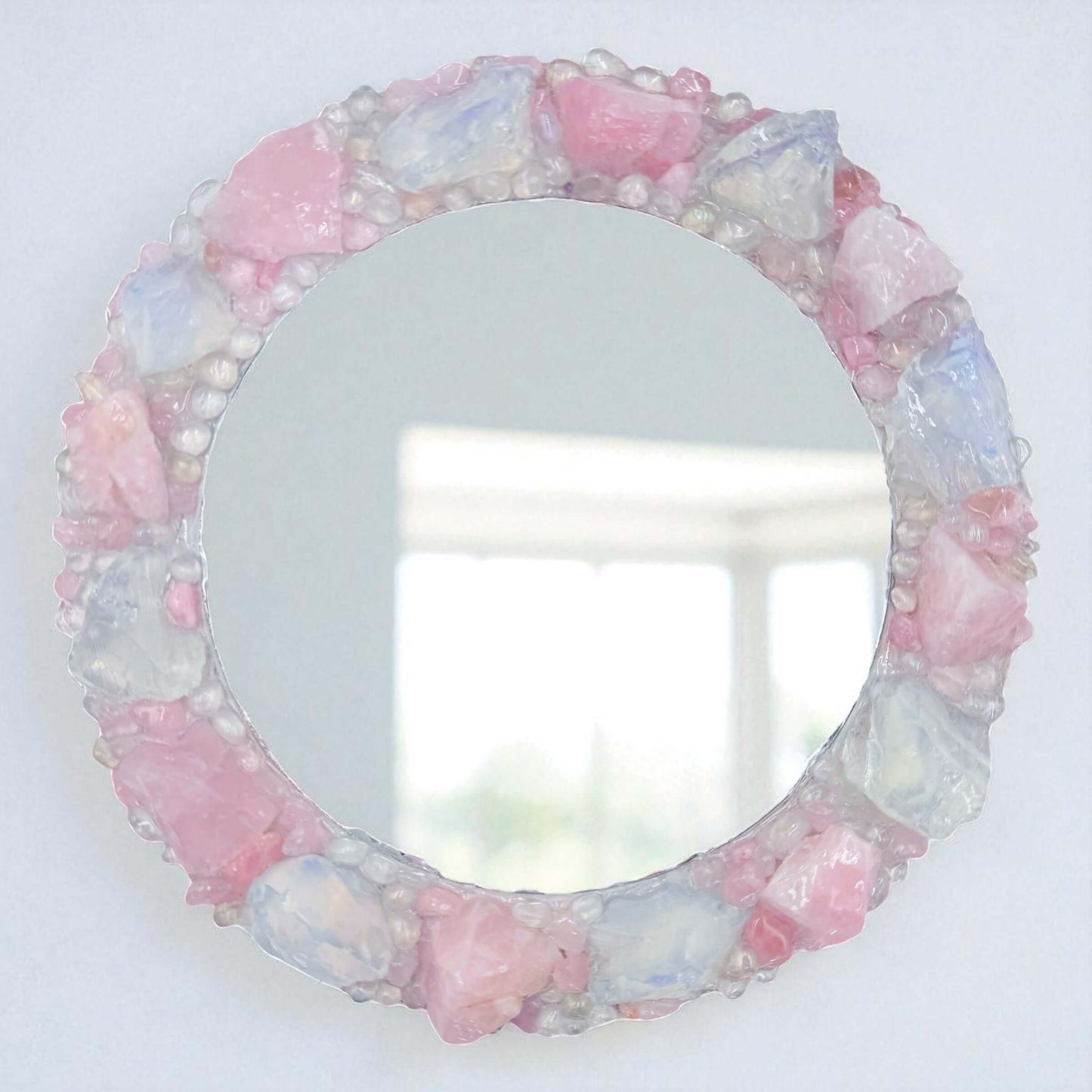 Handmade crystal mirror with gemstone border reflecting natural light