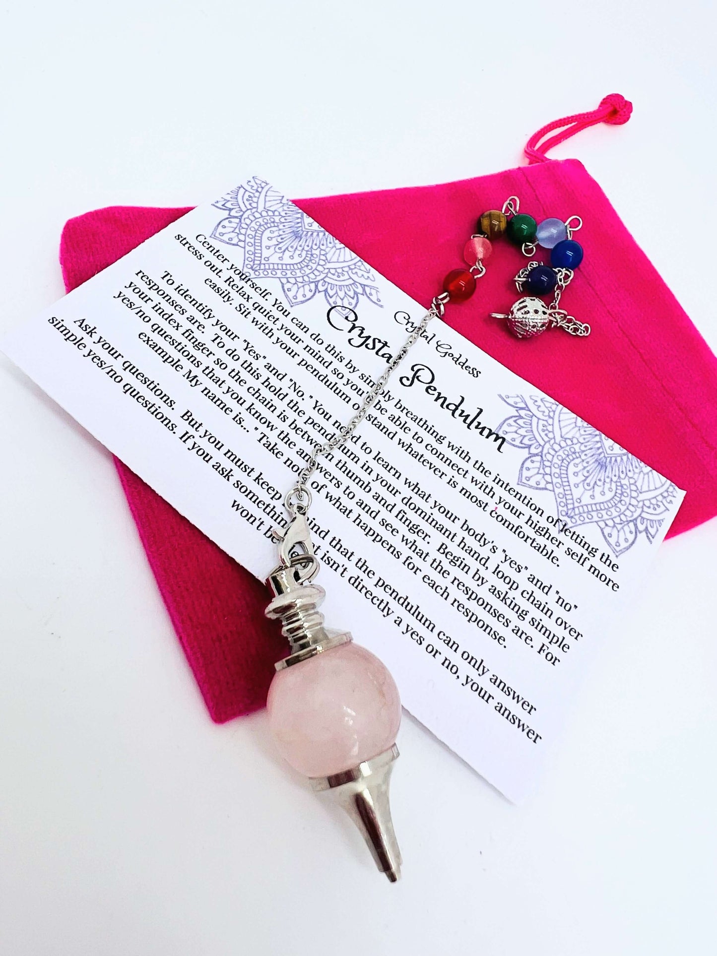 Crystal pendulum with pouch and instructions on white background