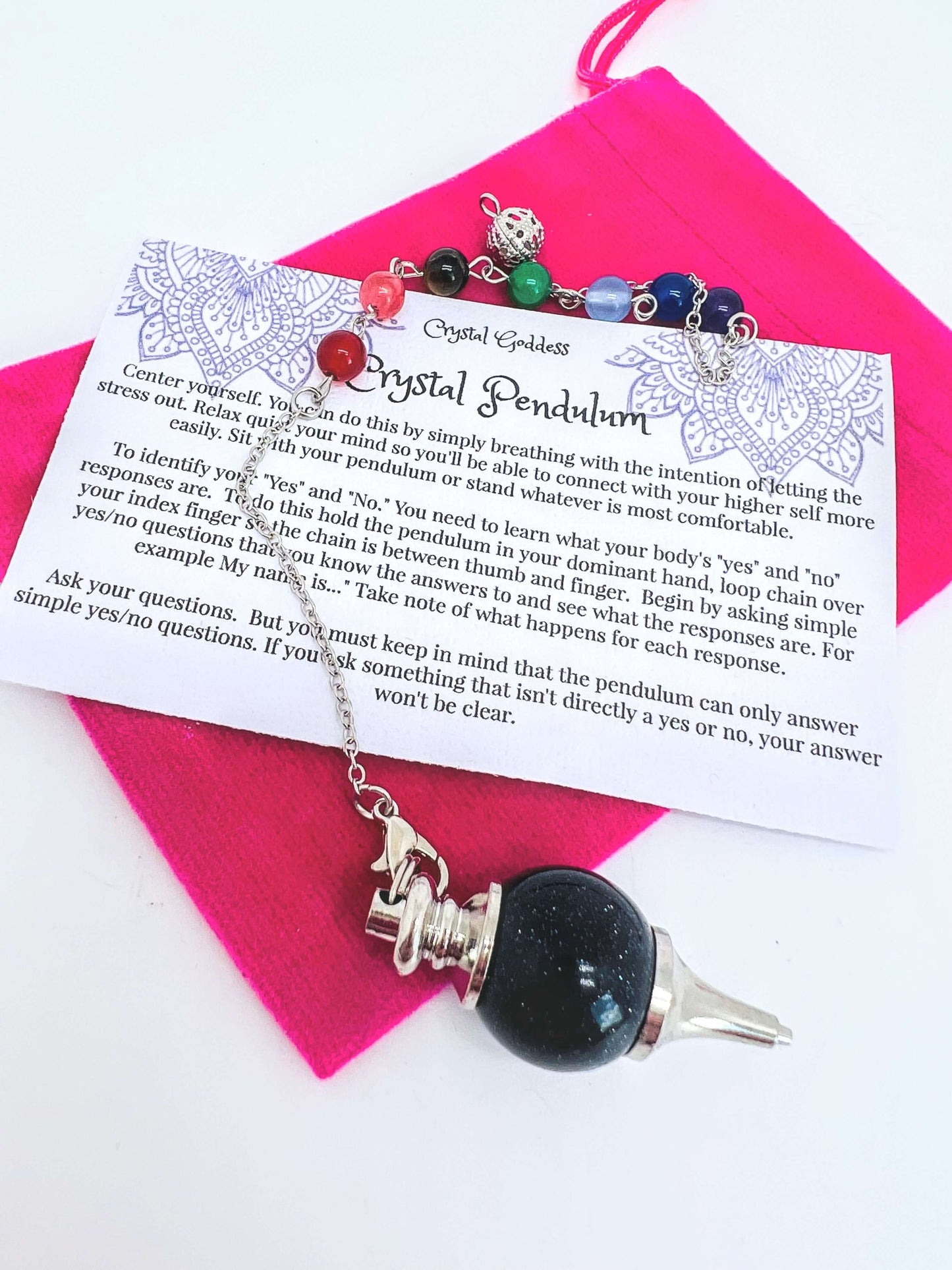 Crystal pendulum with pouch and instructions on white background