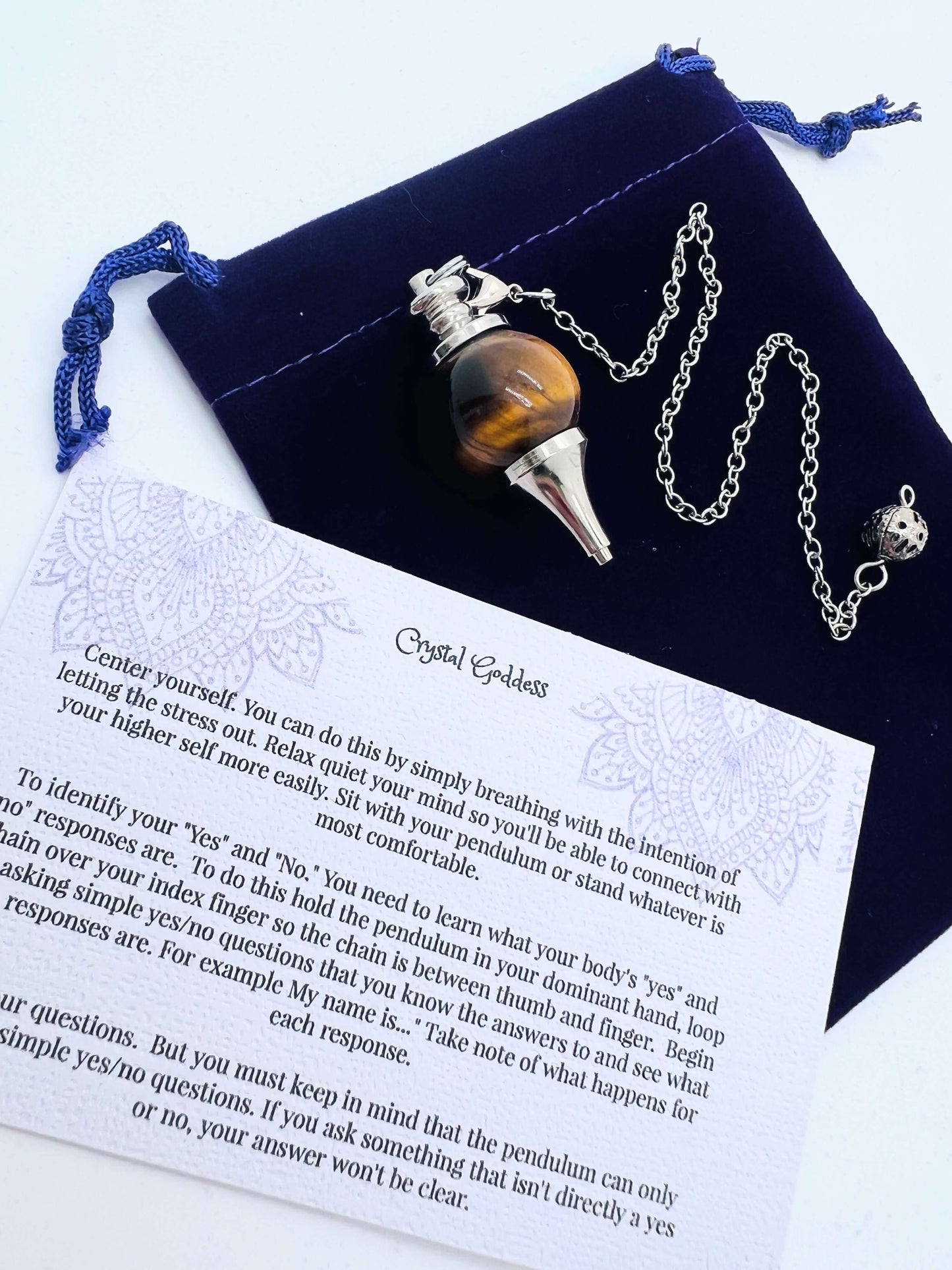 Crystal Ball Pendulum on pouch with information card on white background