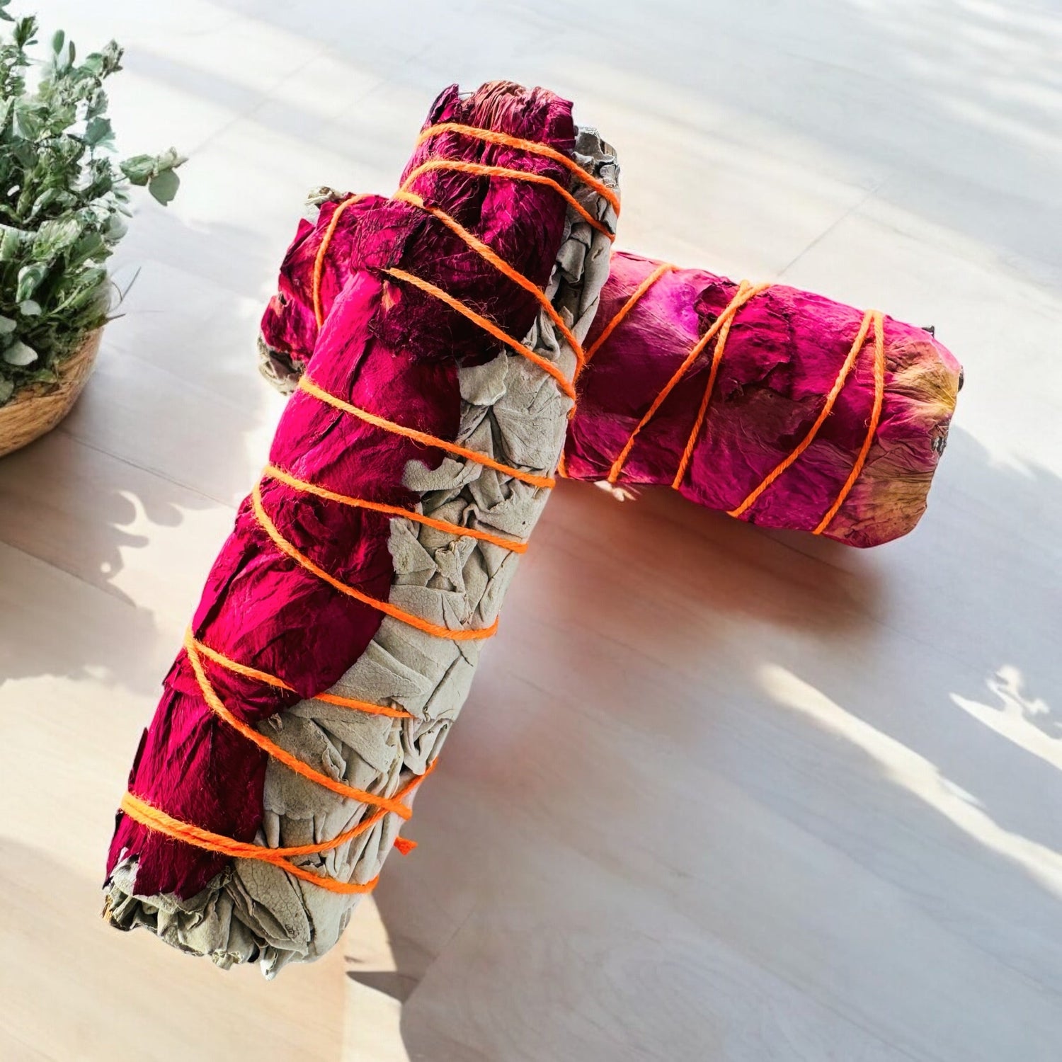 Colorful smudge sticks featuring white sage for energy cleansing on a light wooden surface.