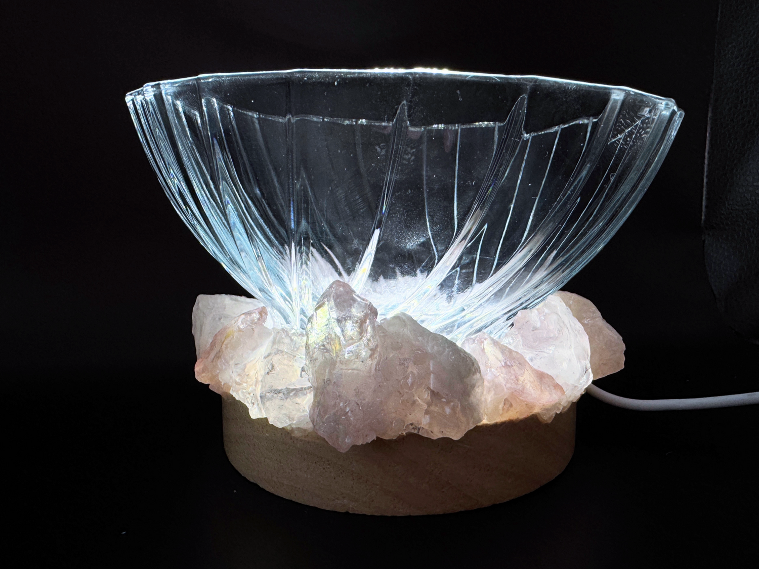 Crystal light bowls featuring a textured glass bowl on a wooden base with natural crystals, creating an ambient glow when illuminated.