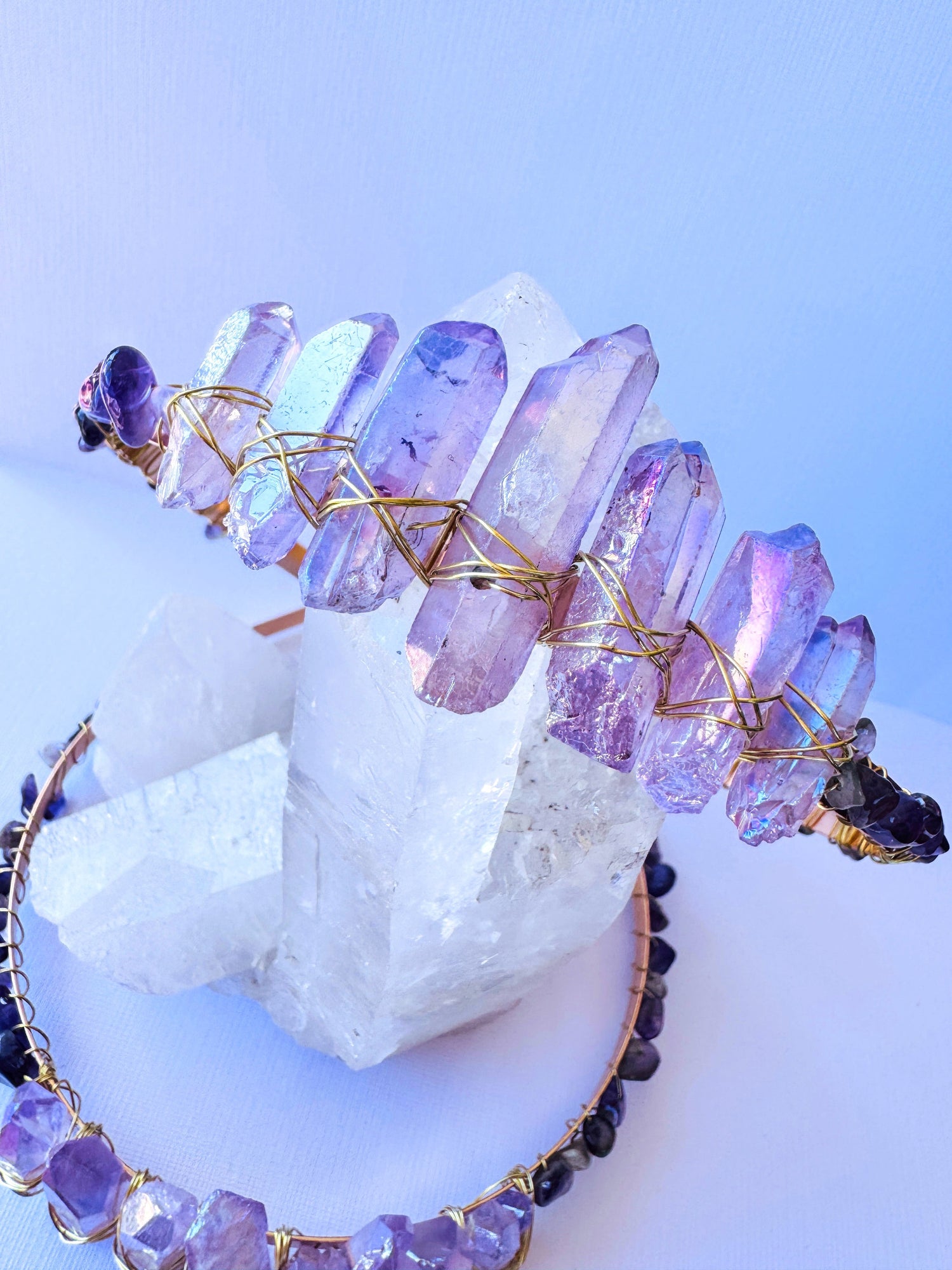 Crystal crown tiara spilling on white surface with candles in background 
