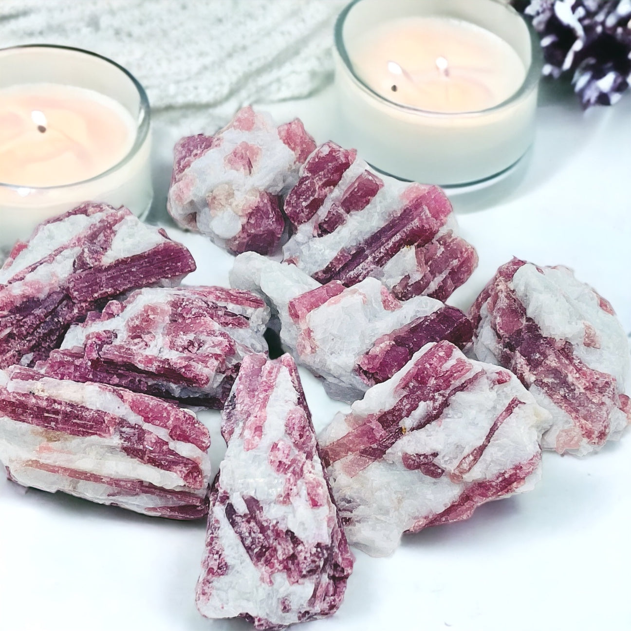 Rough crystals on display surrounded by lit candles