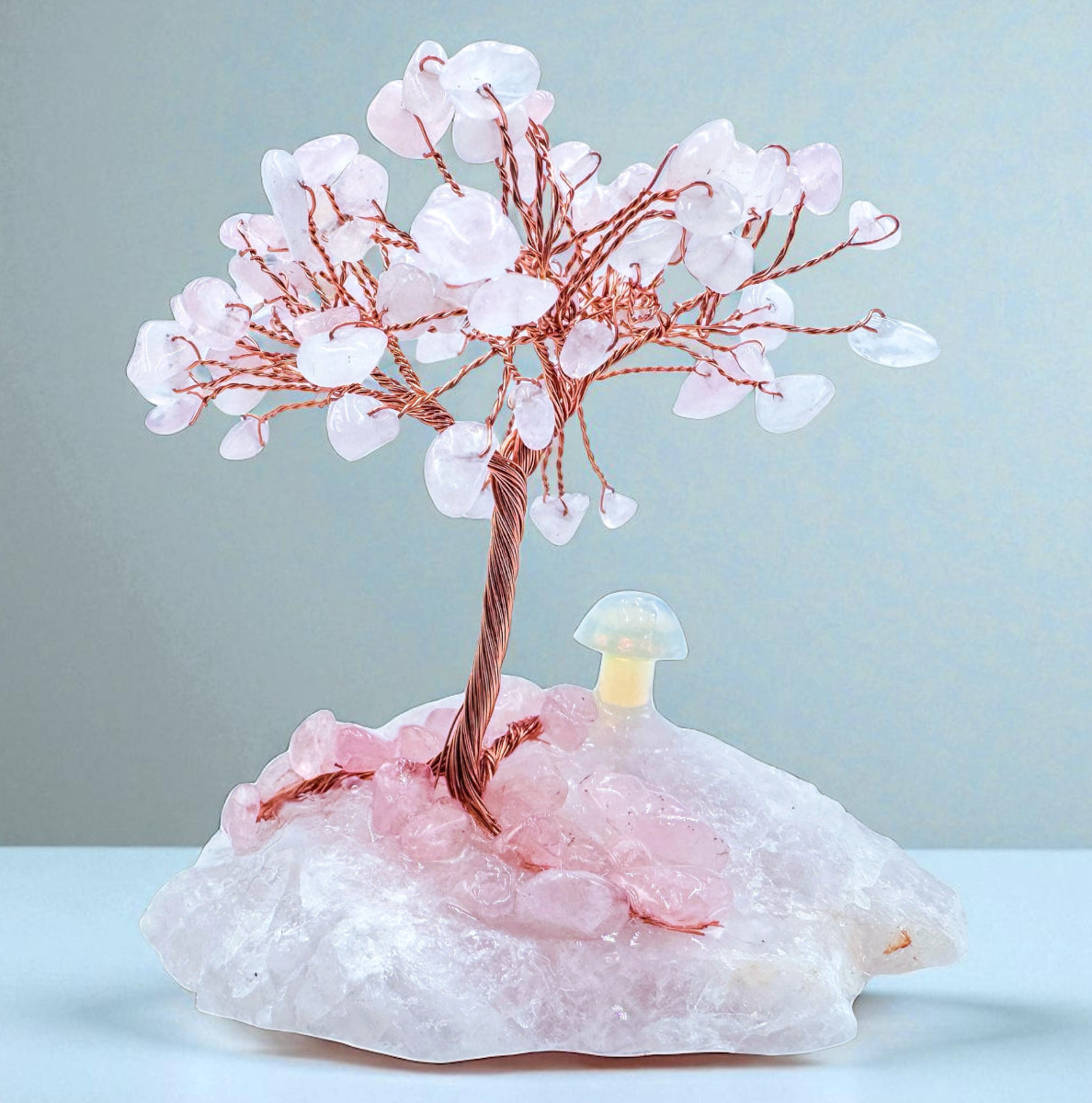 Handcrafted crystal trees featuring a delicate rose quartz design with a natural base, enhancing home décor.