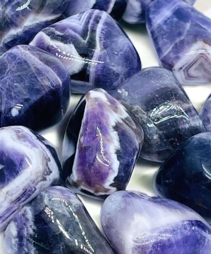 Close-up of polished purple stones in the online shopping collection, featuring vibrant patterns and glossy finishes.