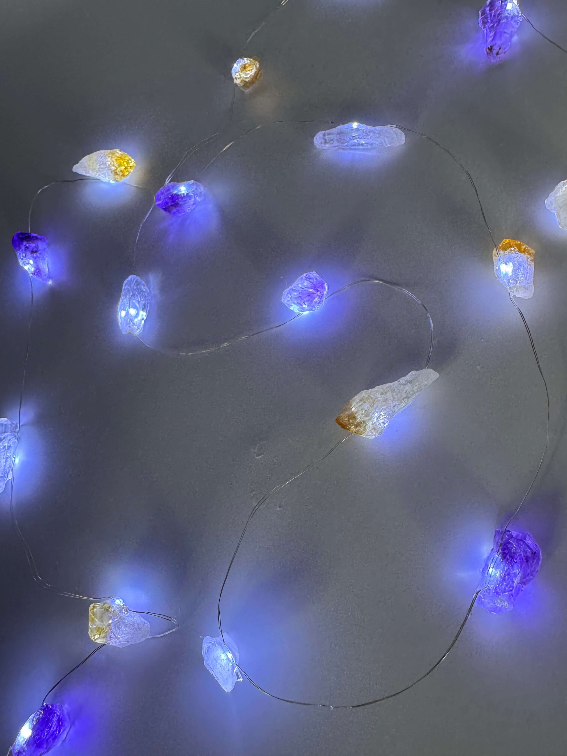 Crystal fairy lights featuring clear quartz, amethyst, and citrine stones with a cool-toned glow, 2m length with 8 light modes.