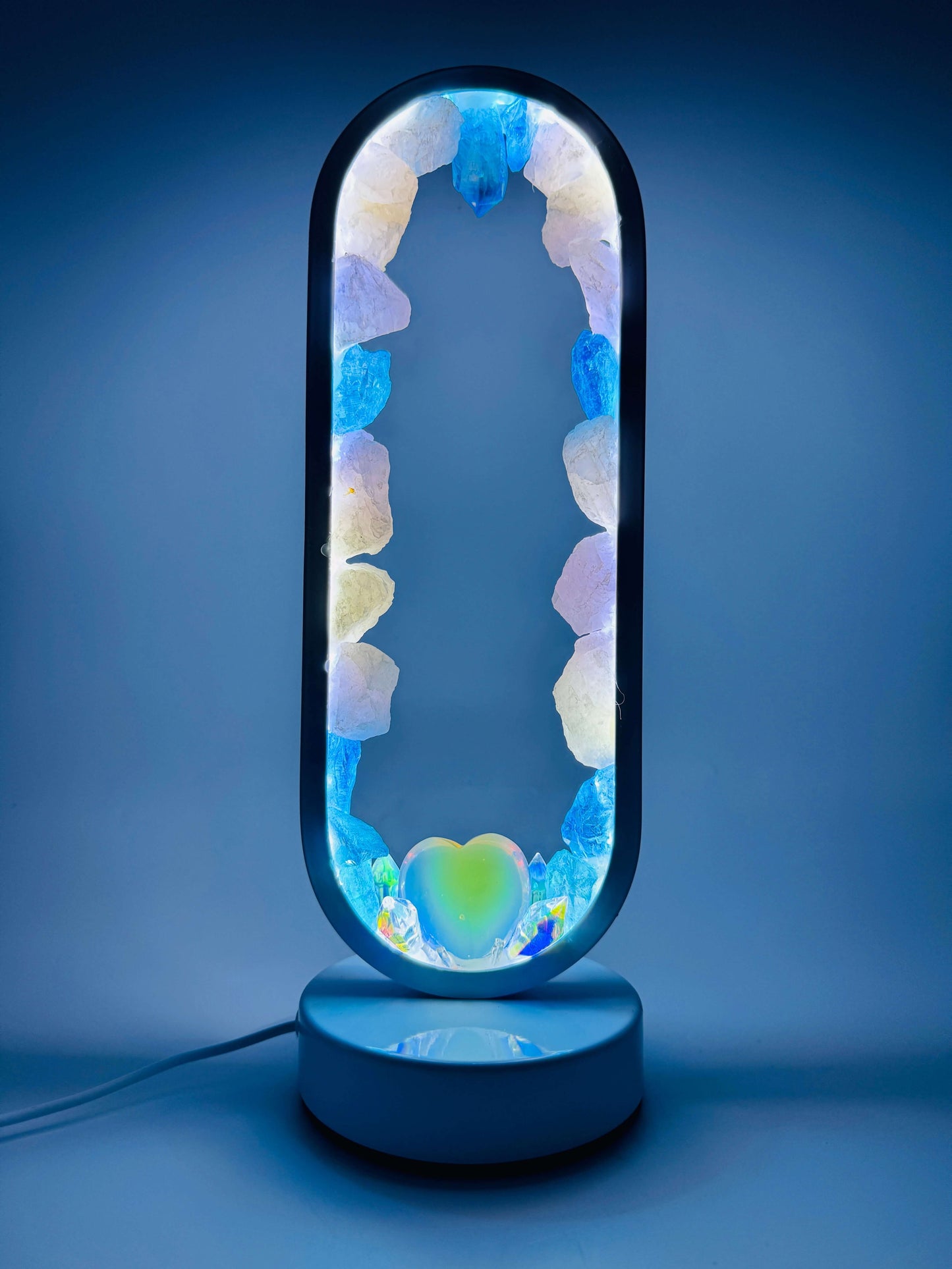 Crystal lamp Ocean of Aphrodite with rose quartz, blue aura quartz, and opalite heart, emitting a calming oceanic glow.