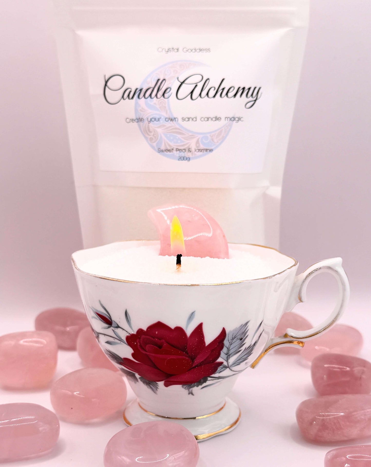 Sand candles in a beautifully decorated teacup with a pink wax piece and wick, showcasing Candle Alchemy magic.