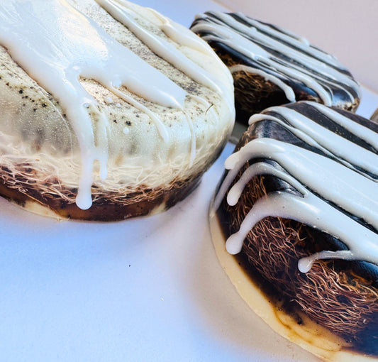 3 round soaps showing loofah inside they are coffee coloured with white drizzles.