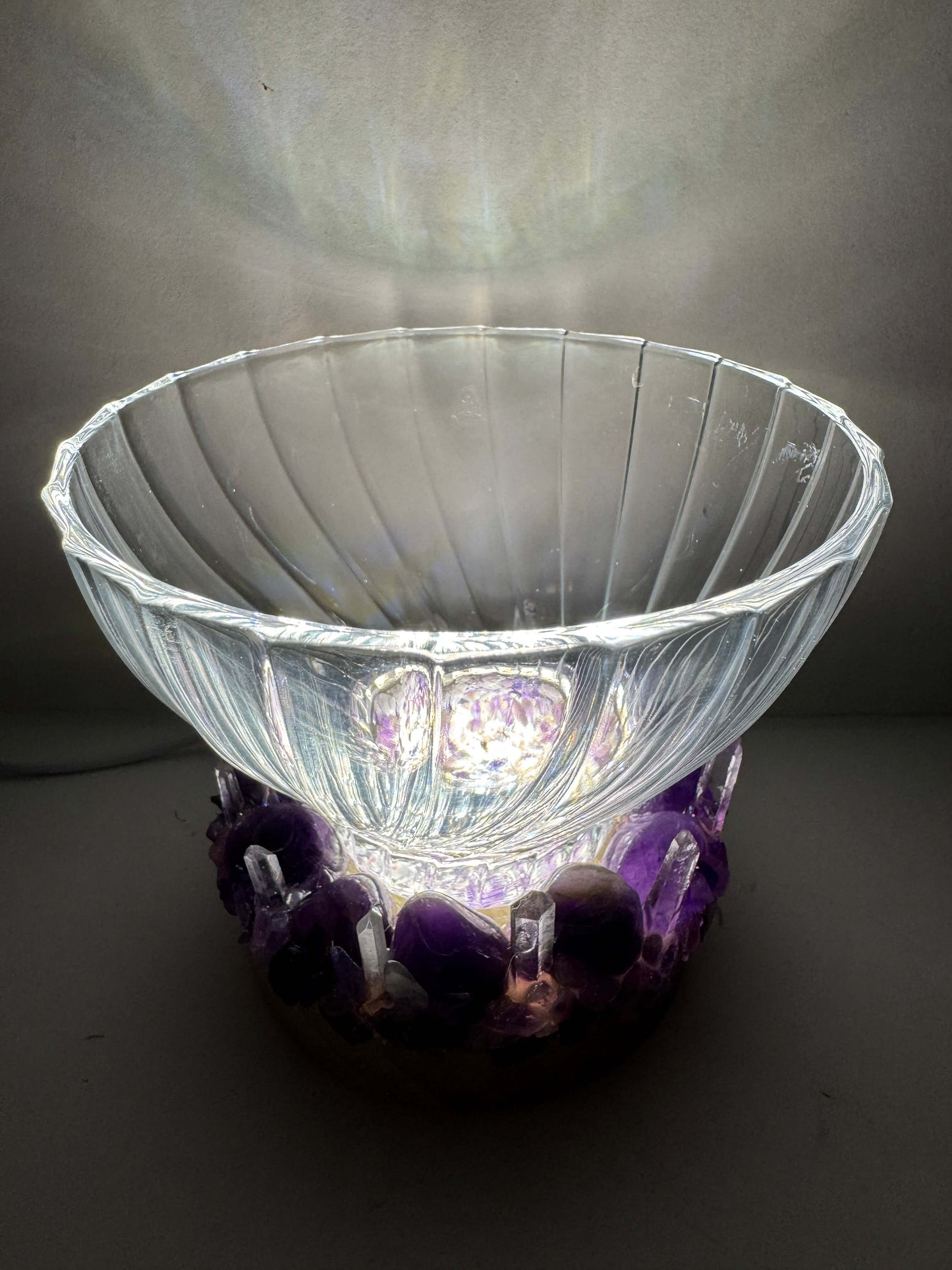 Crystal light bowl with textured glass on LED base featuring amethyst and quartz, emitting soothing ambient glow.