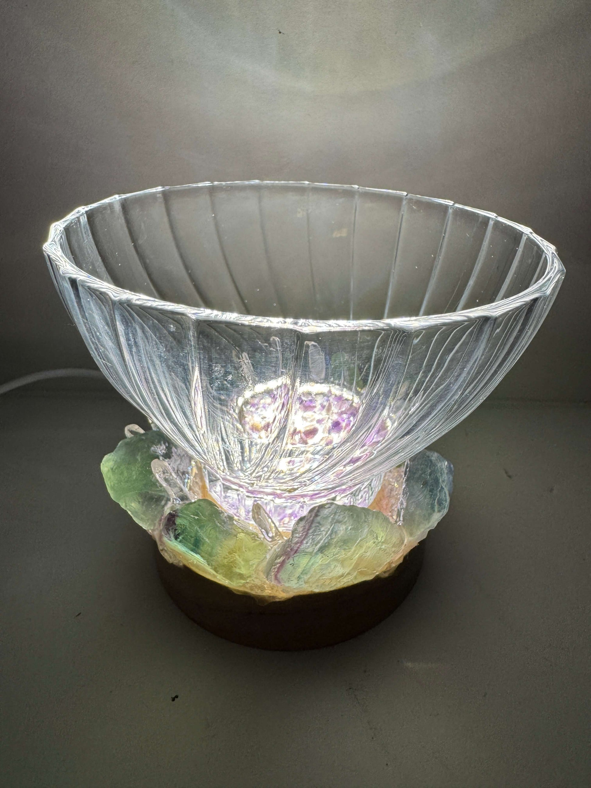 Northern light crystal light bowl featuring fluorite & clear quartz on a wooden LED base, softly illuminating the textured glass.