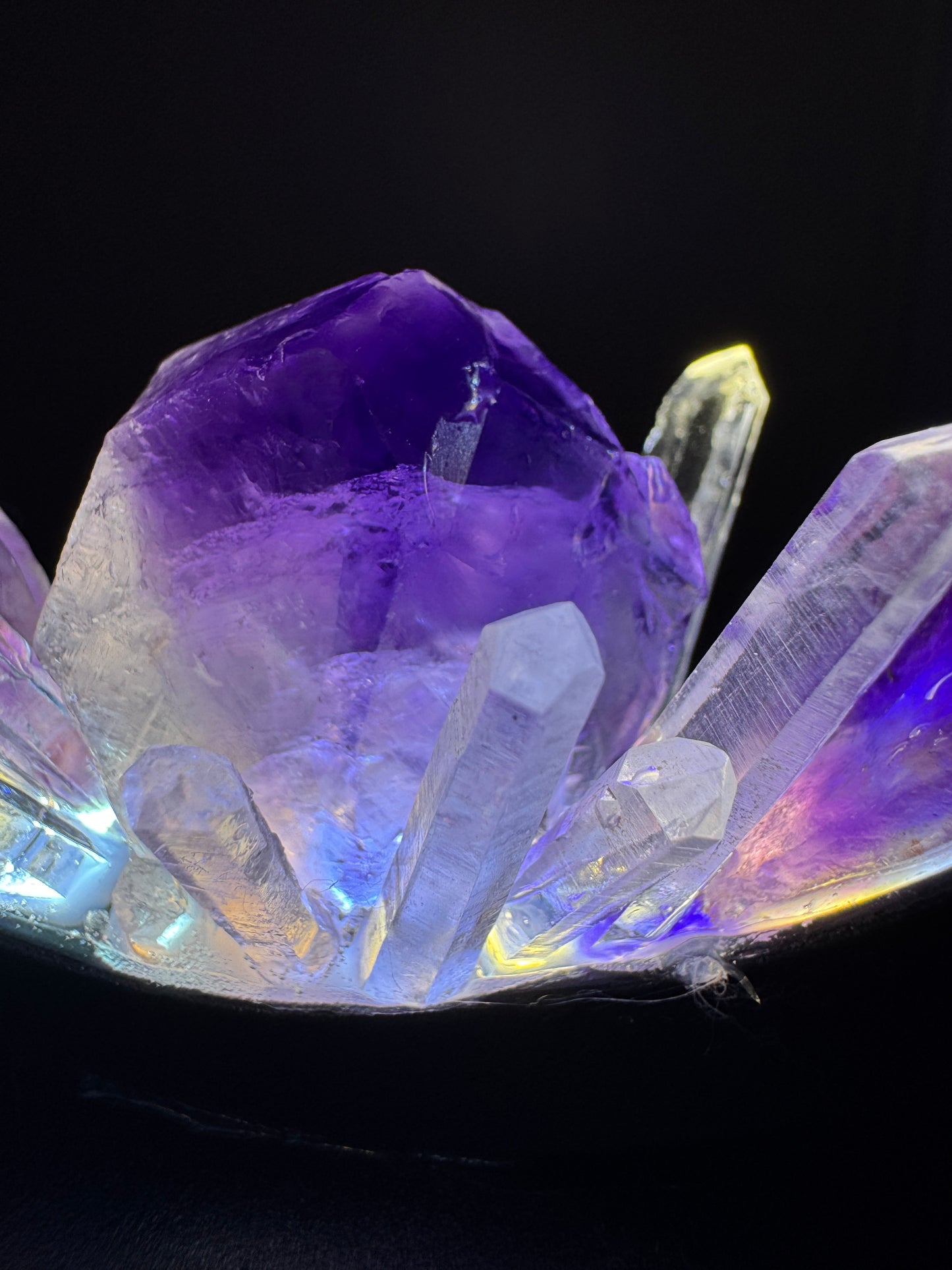 Close-up of illuminated amethyst crystal lamp with rough amethyst and clear quartz points for calm and balance.