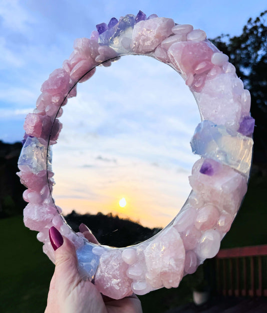 Handmade crystal mirror with gemstone border reflecting natural light