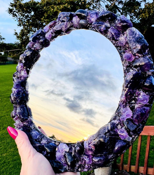 Handmade crystal mirror with gemstone border reflecting natural light