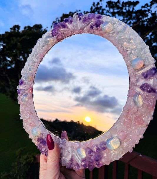 Handmade crystal mirror with gemstone border reflecting natural light