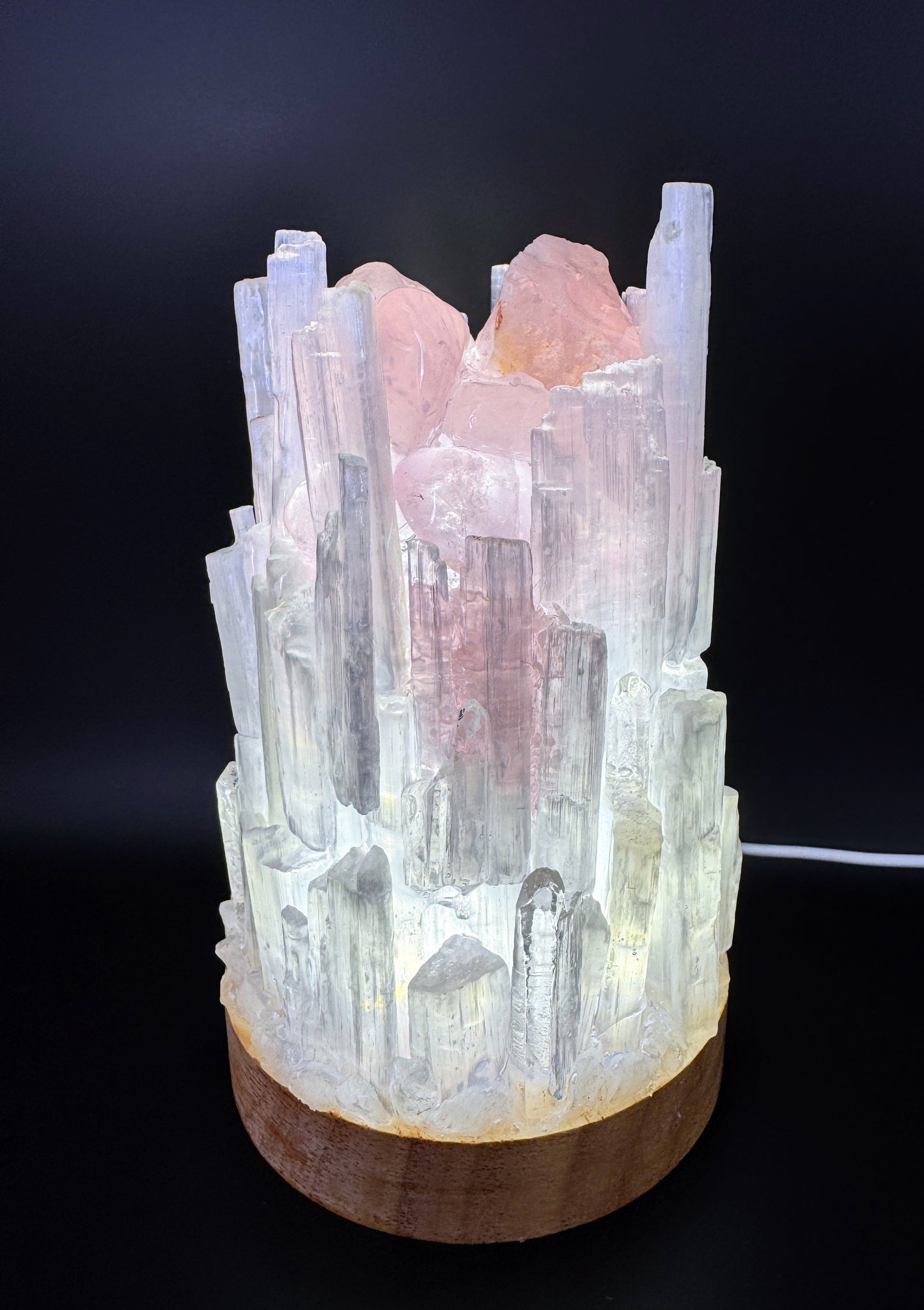 Selenite Crystal Lamp with rose quartz, 10cm base, 15cm tall, resin coated for strength, glowing on a dark background.