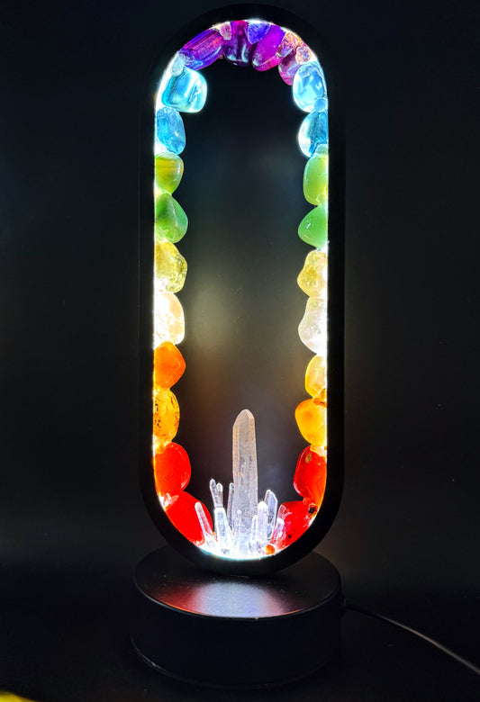 Crystal lamp with polished stones in a rainbow spectrum and clear quartz points, illuminating color and light.