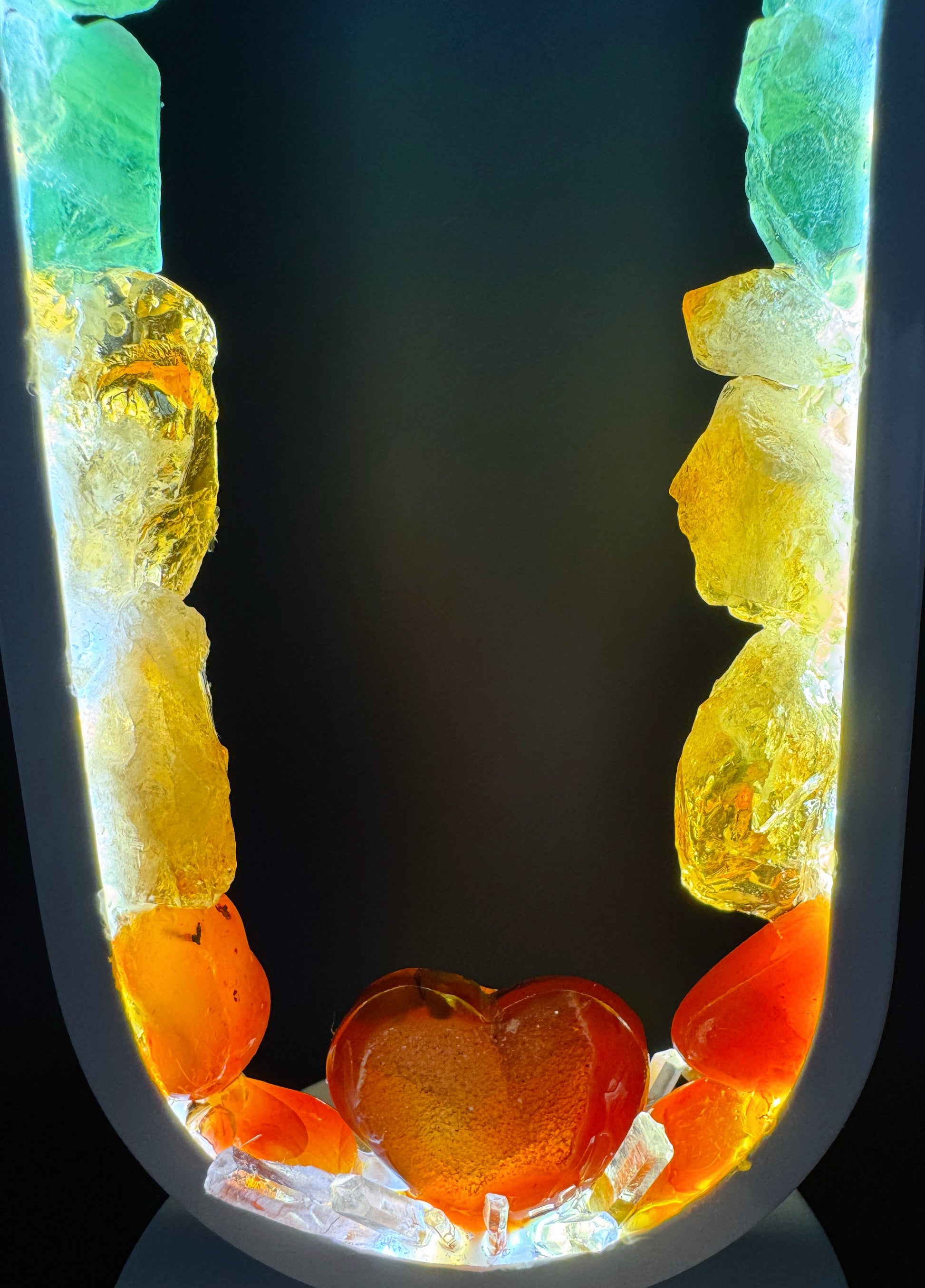 Crystal Lamp featuring Carnelian Heart and rough rainbow stones, creating a glowing, diffused light effect.