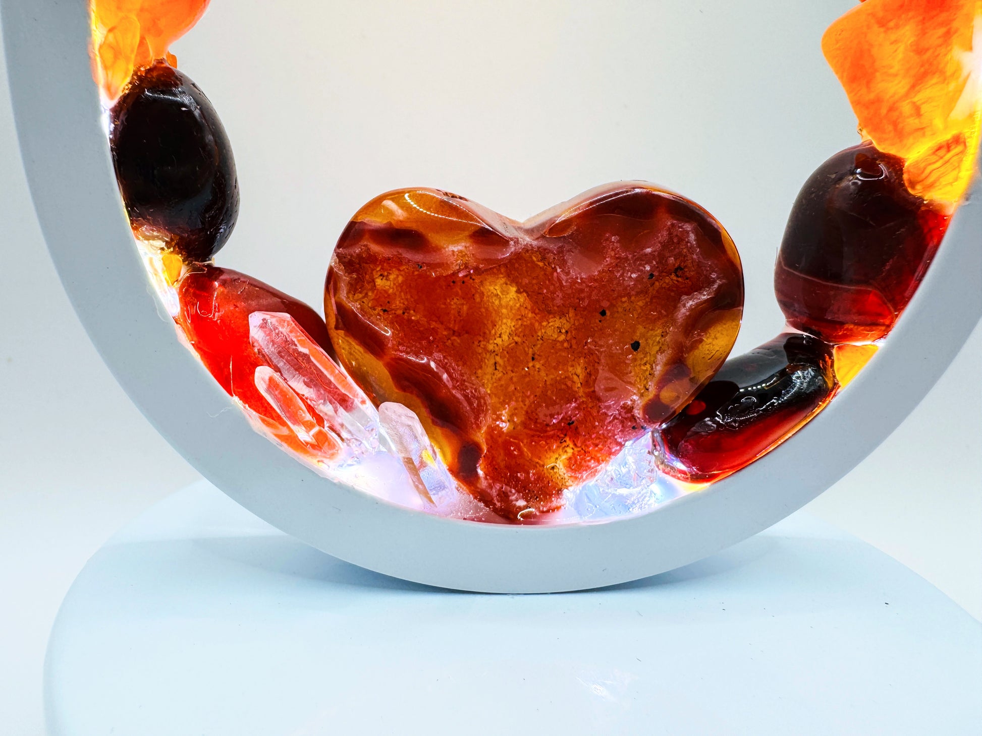 Crystal Lamp with a carnelian heart centerpiece glowing within a rainbow of polished stones.