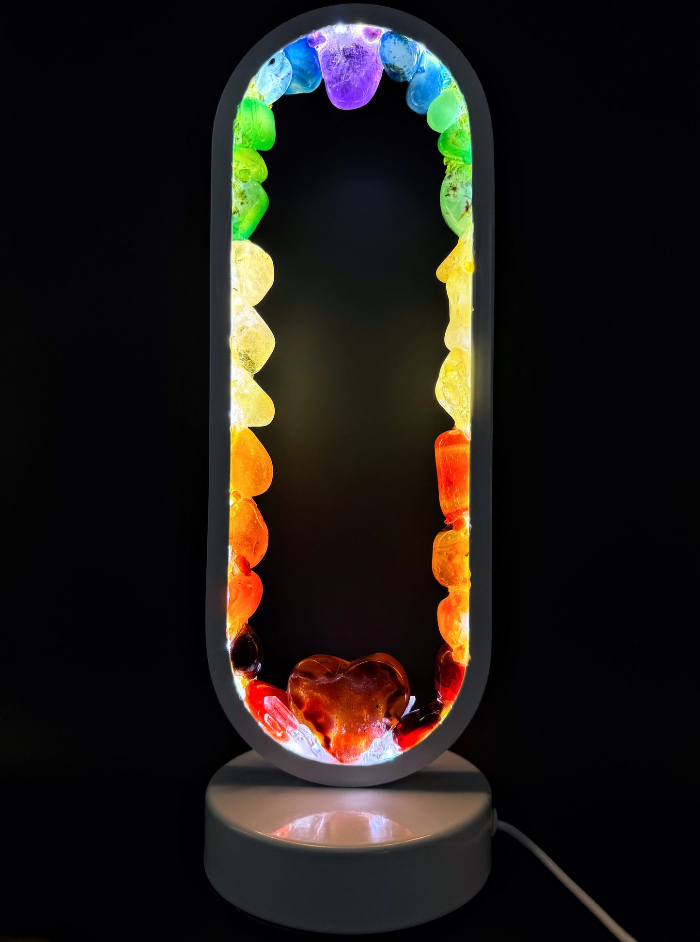 Crystal Lamp “Rainbow Love” featuring polished stones in a rainbow spectrum and a carnelian heart at the base.