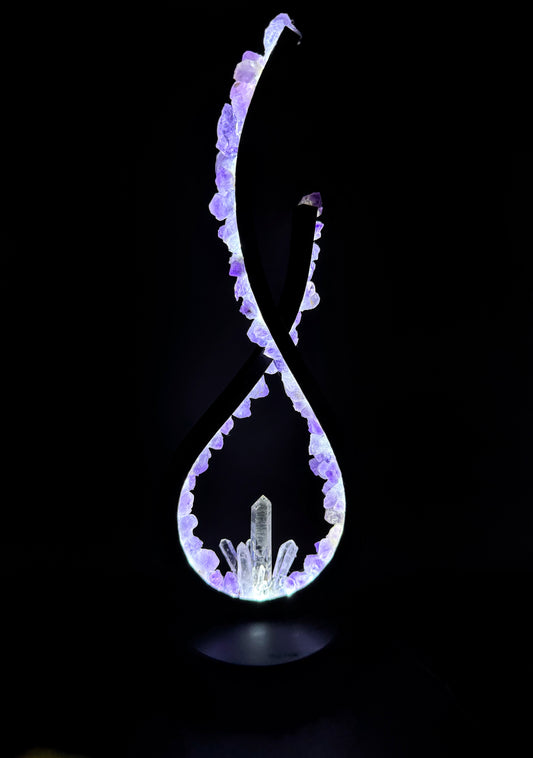 Crystal Lamp featuring amethyst flowers and clear quartz points, illuminating a flame-inspired design.
