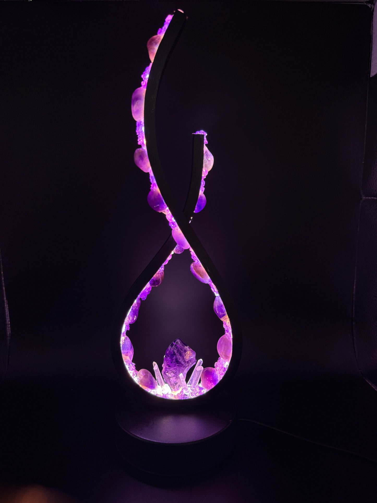 Crystal lamp Lavender Love featuring polished amethyst stones and a central amethyst point, glowing violet.