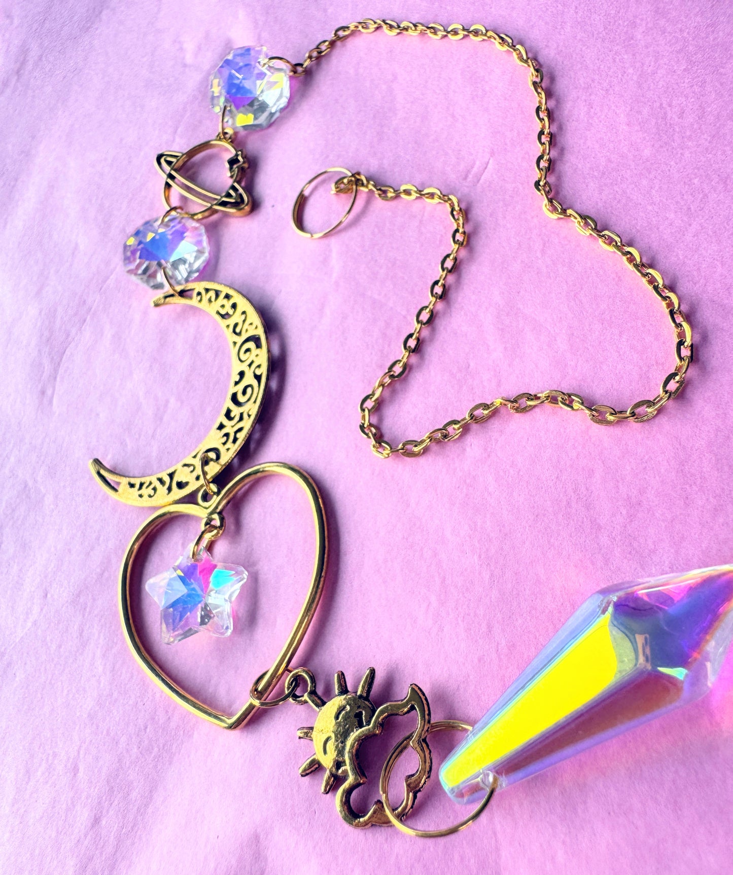 Iridescent Gold Heart Sun catcher with heart and crescent moon on pink back ground 