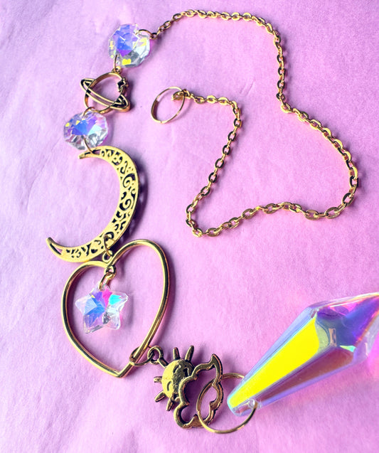 Iridescent Gold Heart Sun catcher with heart and crescent moon on pink back ground 