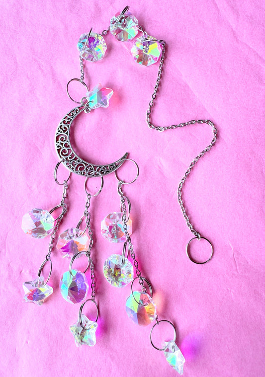 Iridescent cascade sun catcher Lying on pink background 