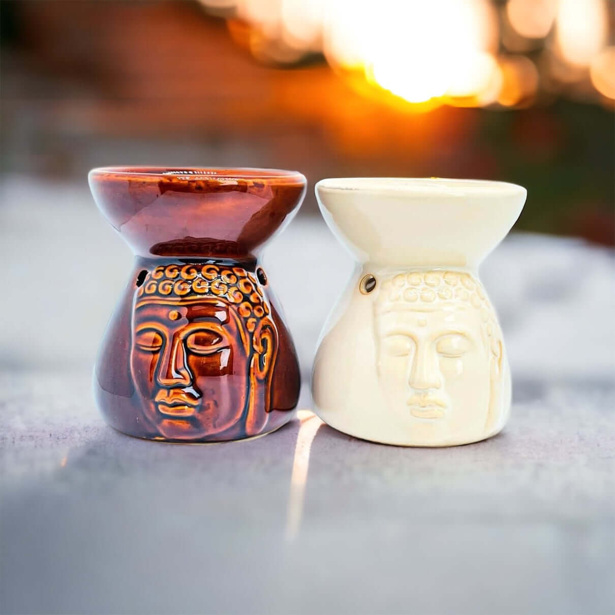 Buddha oil burners with sun set in background