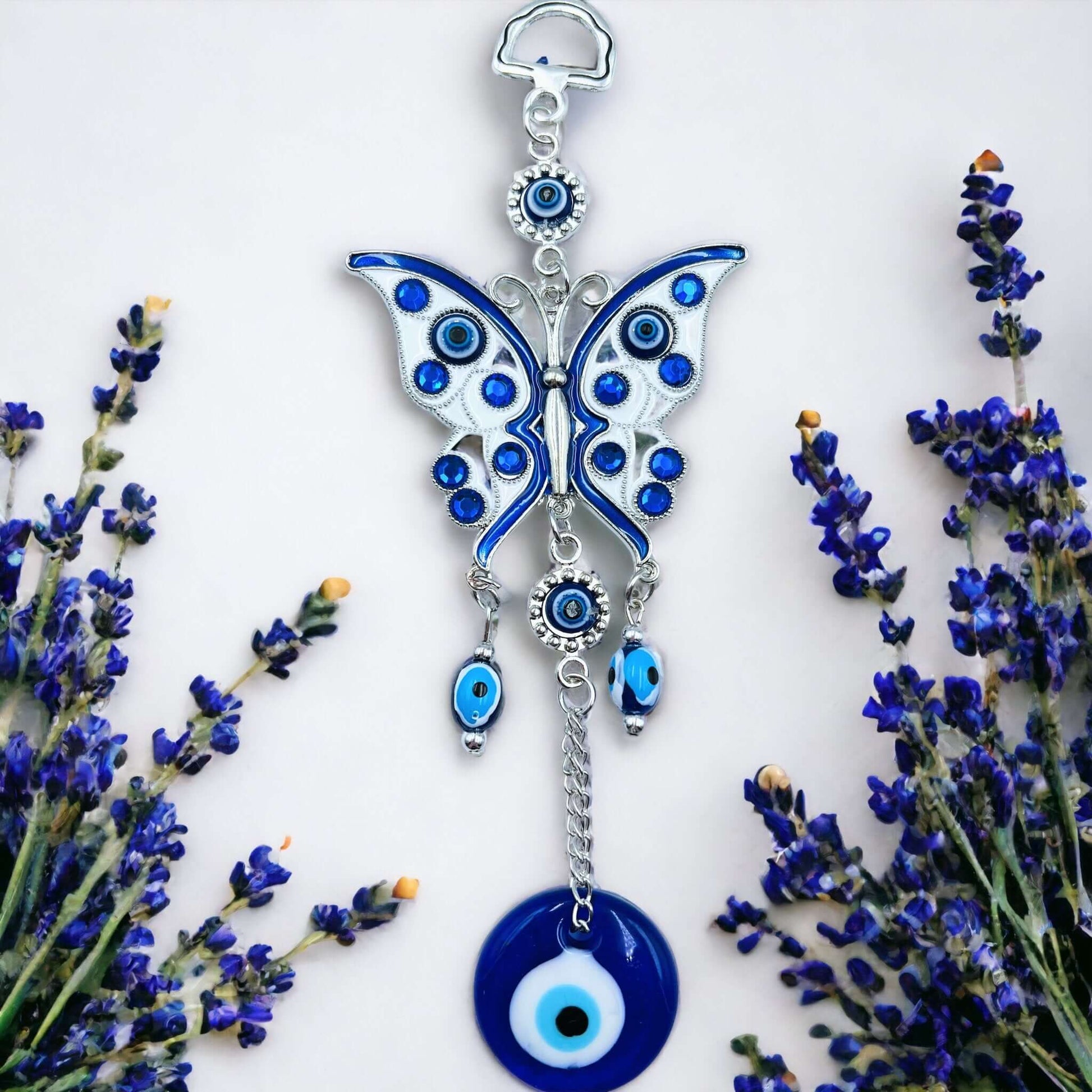 Butterfly evil eye hanger on white surface.