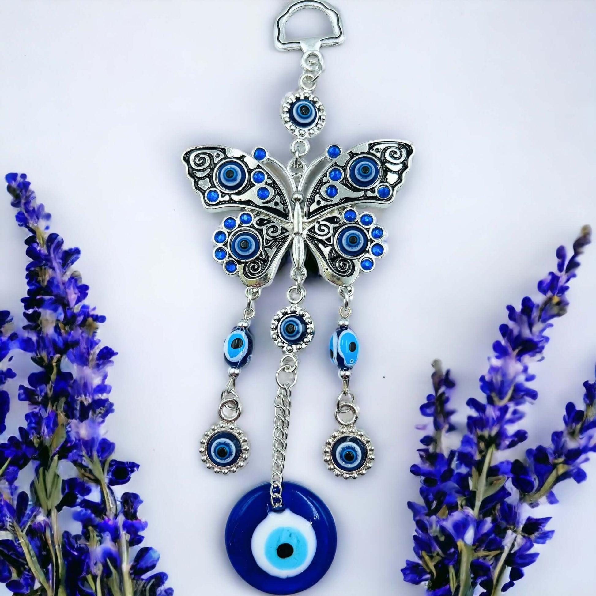 Butterfly evil eye hanger on white surface.