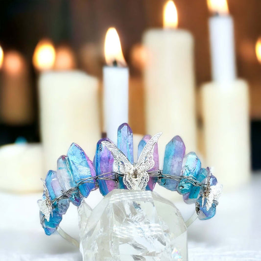 Crystal crown tiara on white surface with candles in background.
